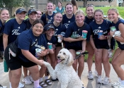 Stella the therapy dog poses with student-athletes during an event at College of Saint Mary.
