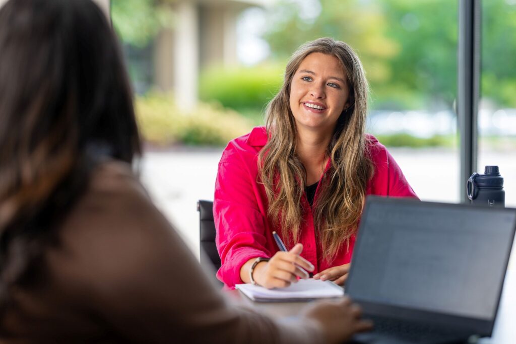 girl sitting at desk smiling