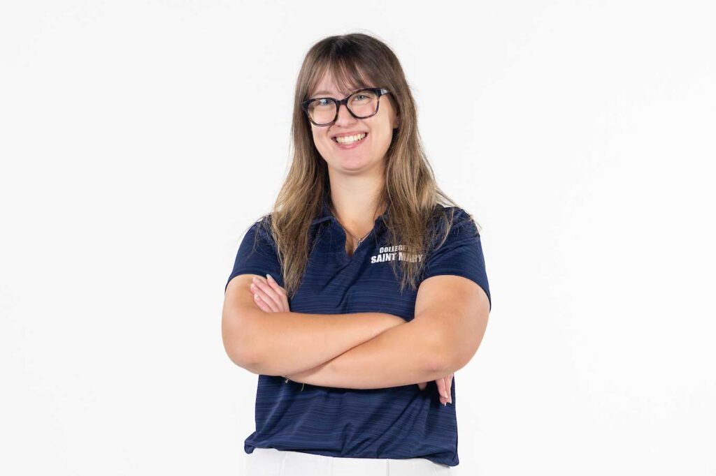 Young woman standing against a plain white background, facing the camera