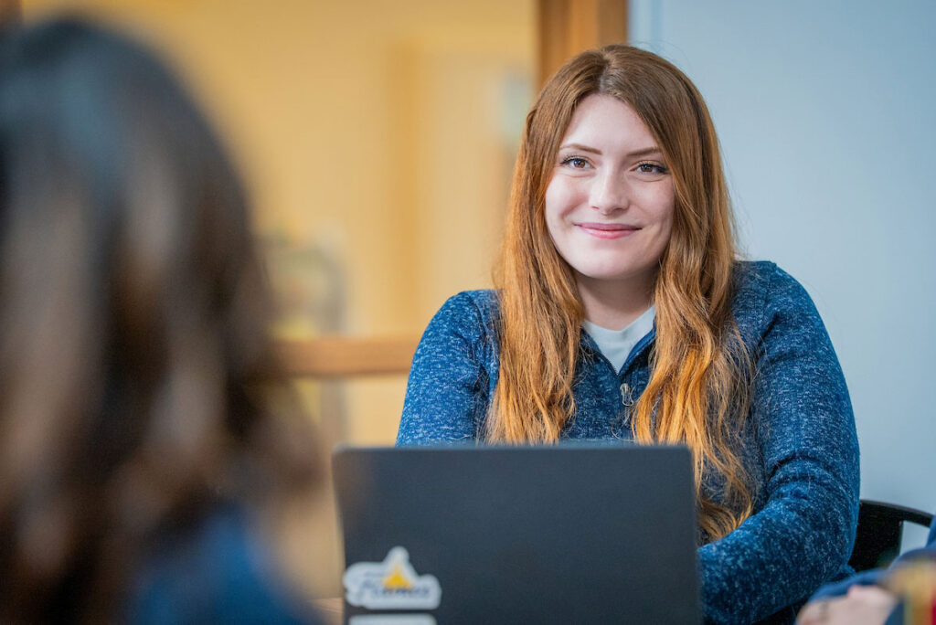 Student sitting at a laptop in a classroom.