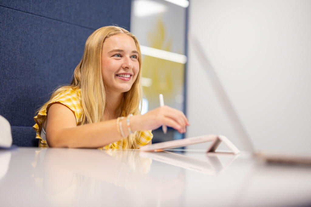 Student working on iPad in a study booth.
