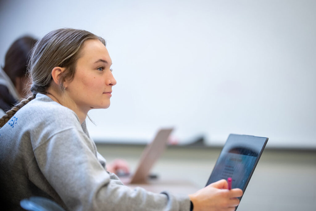 Young woman in classroom lecture hall in Hill-Macaluso Hall at College of Saint Mary.