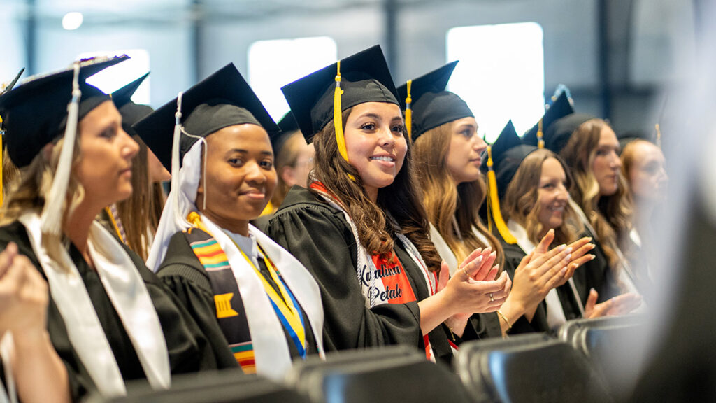 a smiling group of students in graduation attire