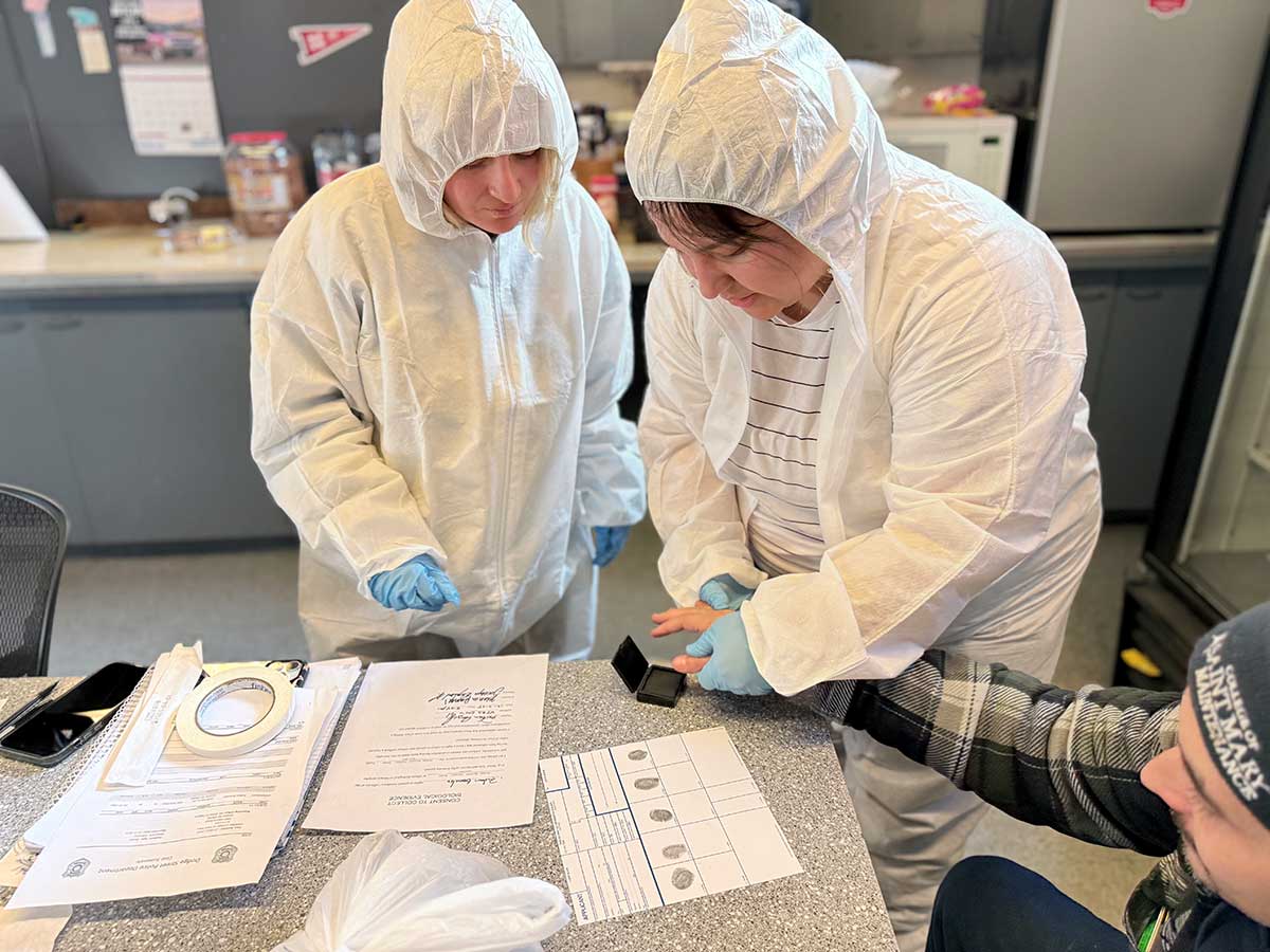 Forensic science students take fingerprints as part of gathering evidence.