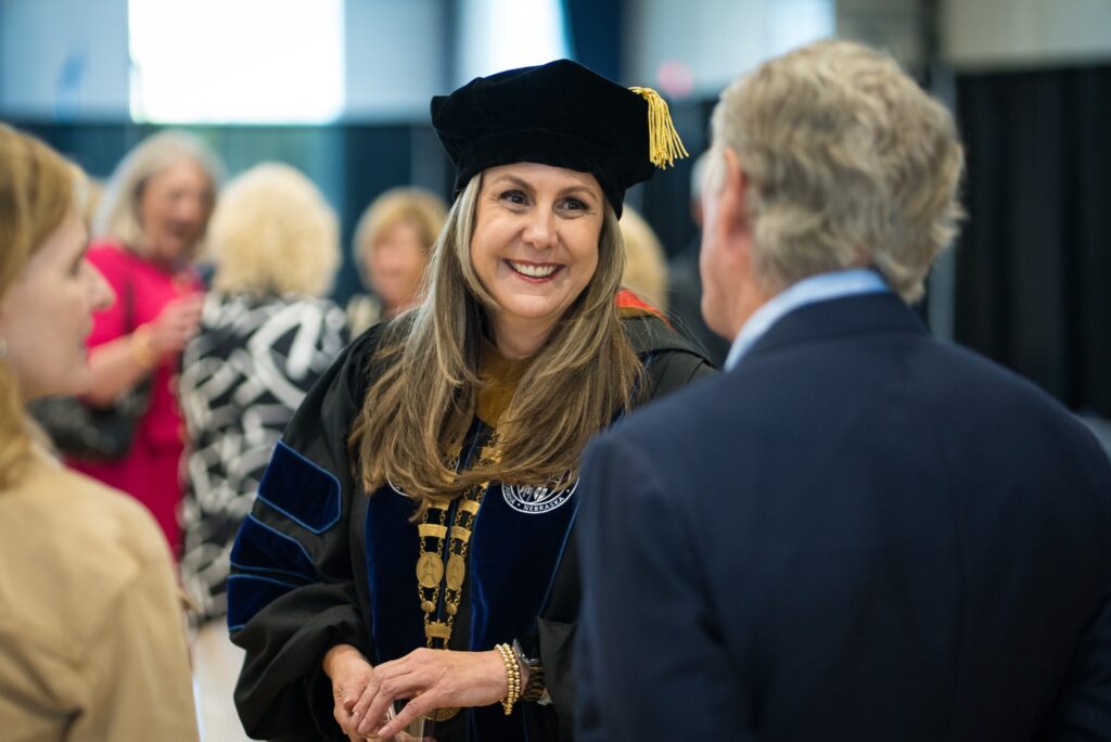 woman in graduate gown smiling at man