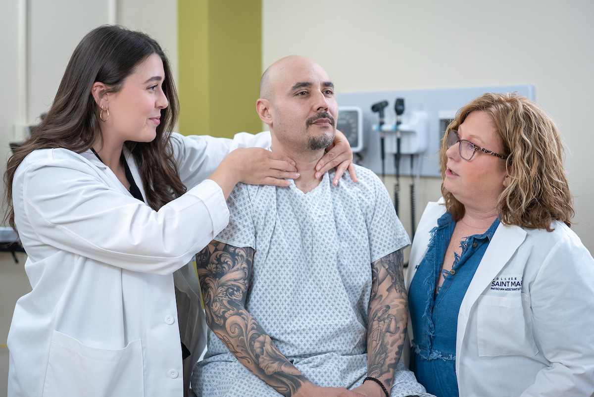 Physician Assistant student and professor perform thyroid exam on patient.
