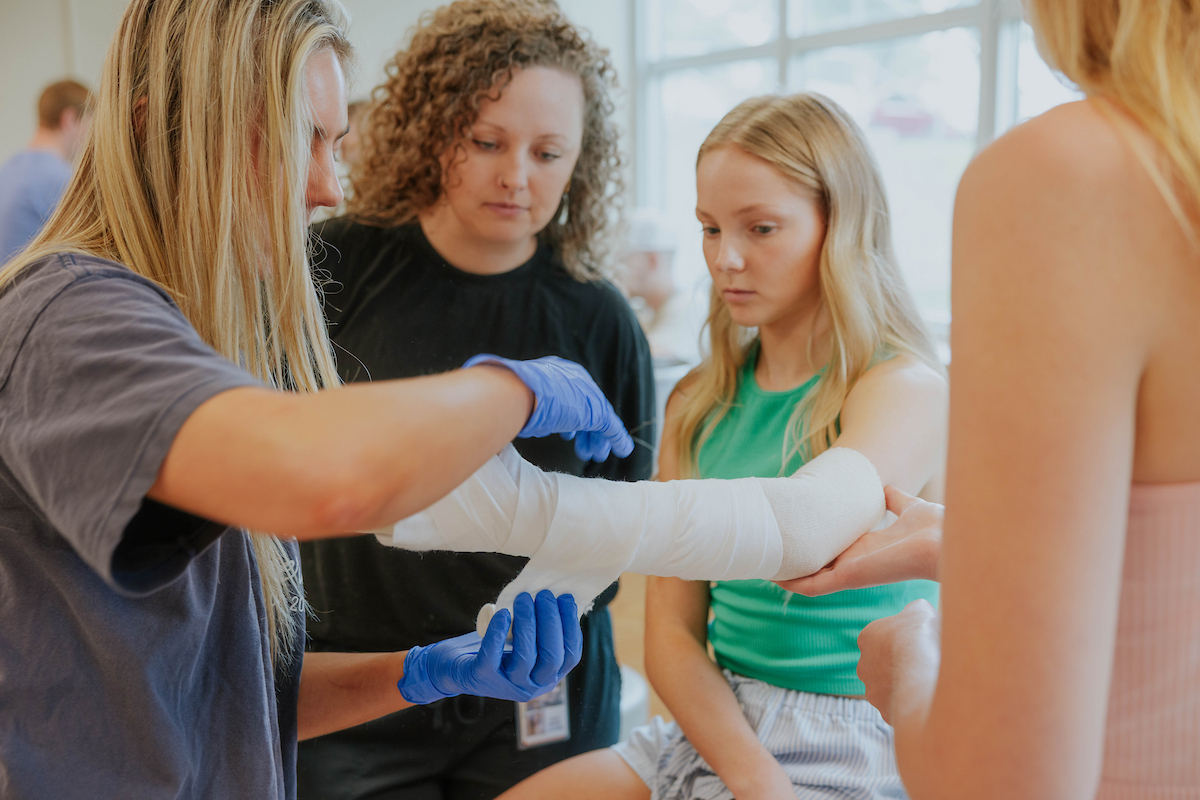 student practicing putting a cast on another student