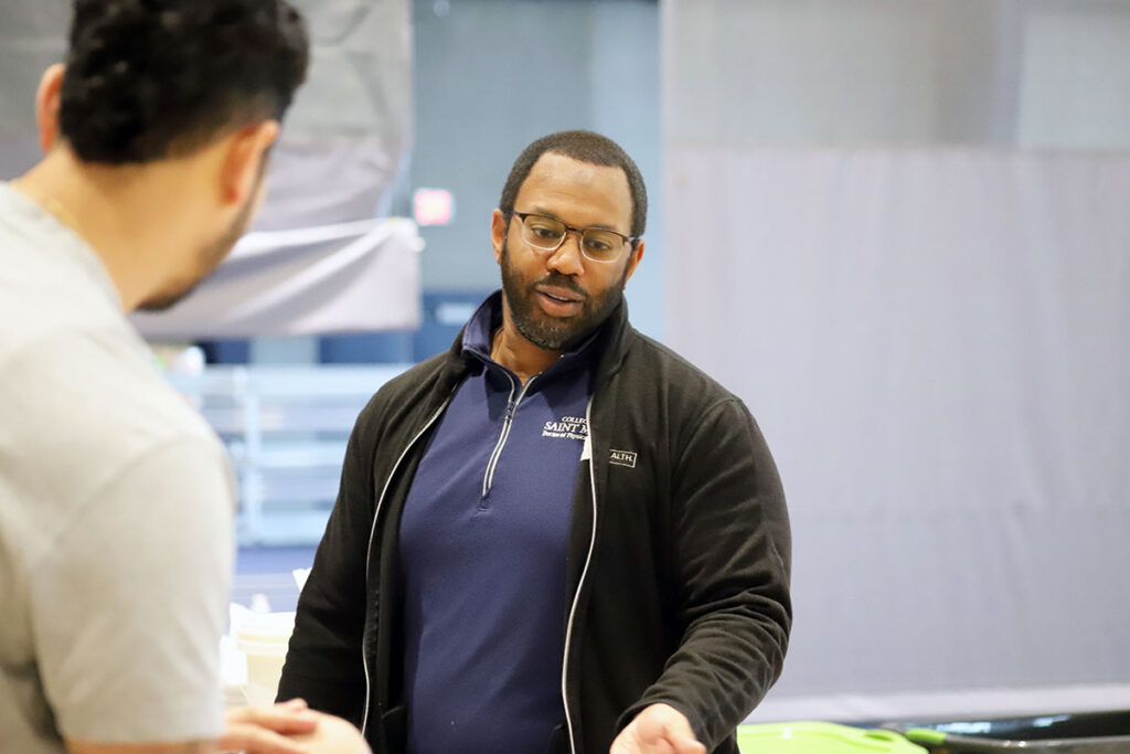 Instructor and student converse in an indoor campus setting.