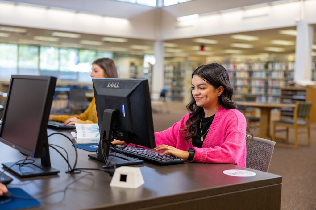 Students working at desktop computers in the campus library