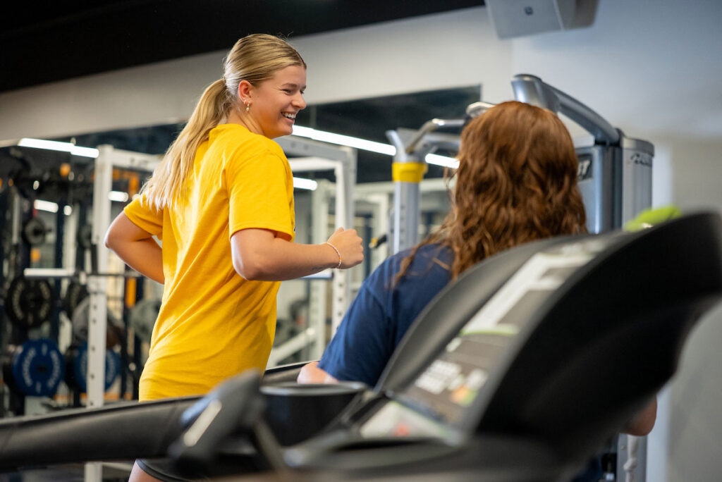 Student and coach in weight room in Lied Fitness Center at College of Saint Mary.