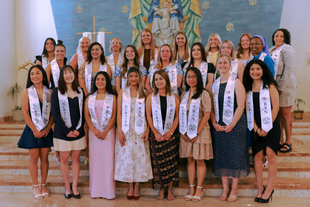 The 2026 Bachelor of Science in Nursing class stands together in the campus chapel after their pinning ceremony.