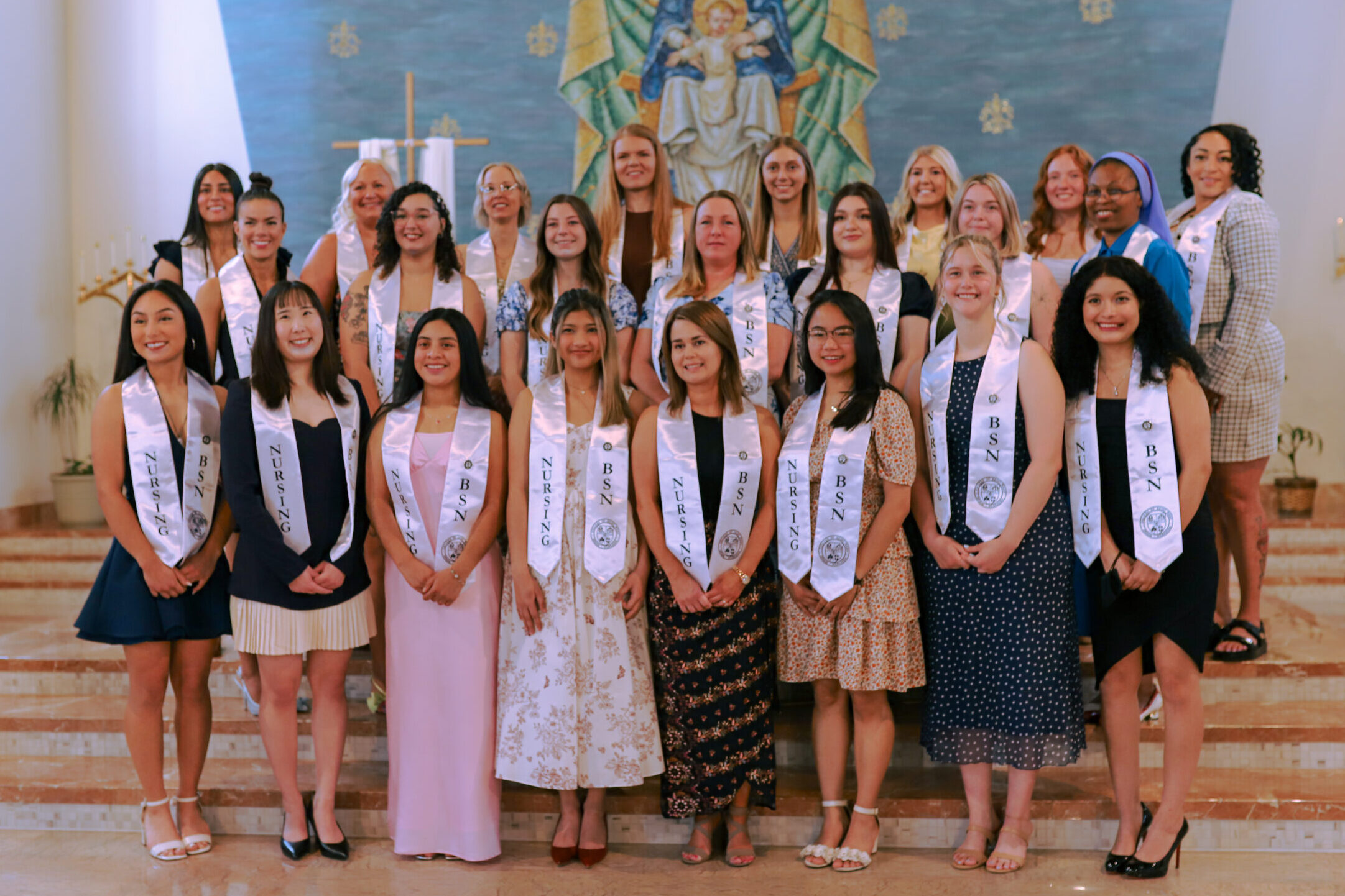 The 2026 Bachelor of Science in Nursing class stands together in the campus chapel after their pinning ceremony.