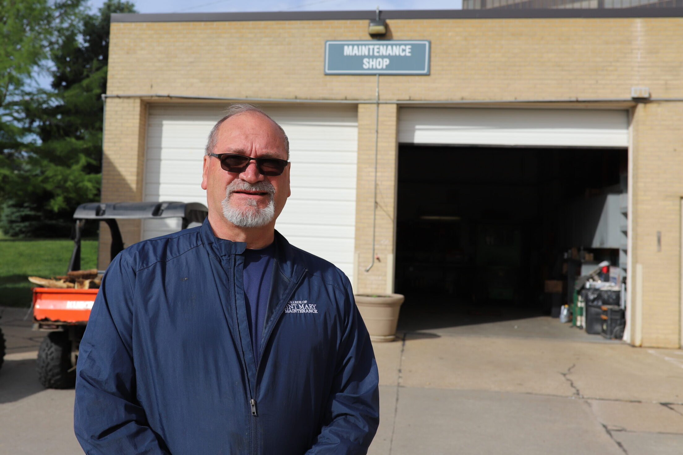 Leroy Peters, assistant director of facilities, stands in front of the maintenance shop on campus.