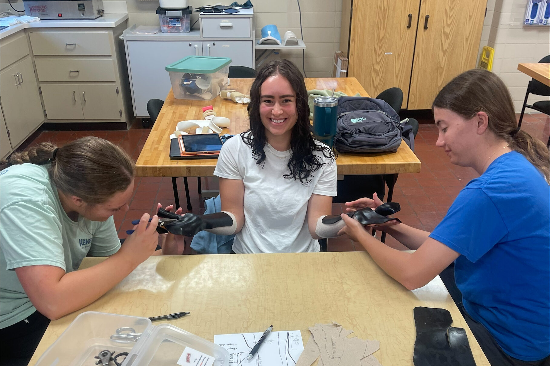 Occupational therapy student Lillie O'Connor practices OT skills with two other students.