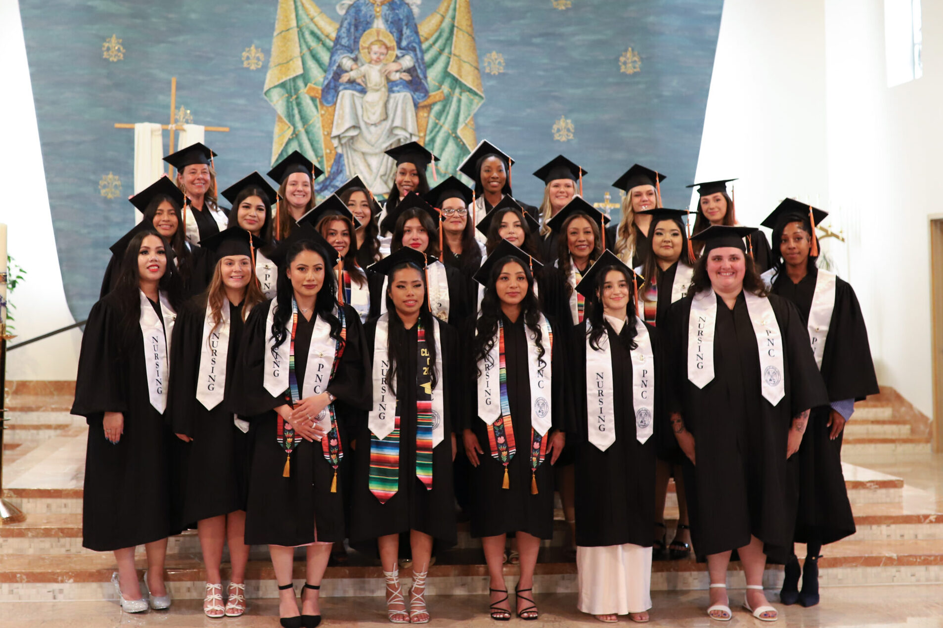 Practical nursing certificate PNC graduates stand together in the chapel after their pinning ceremony.