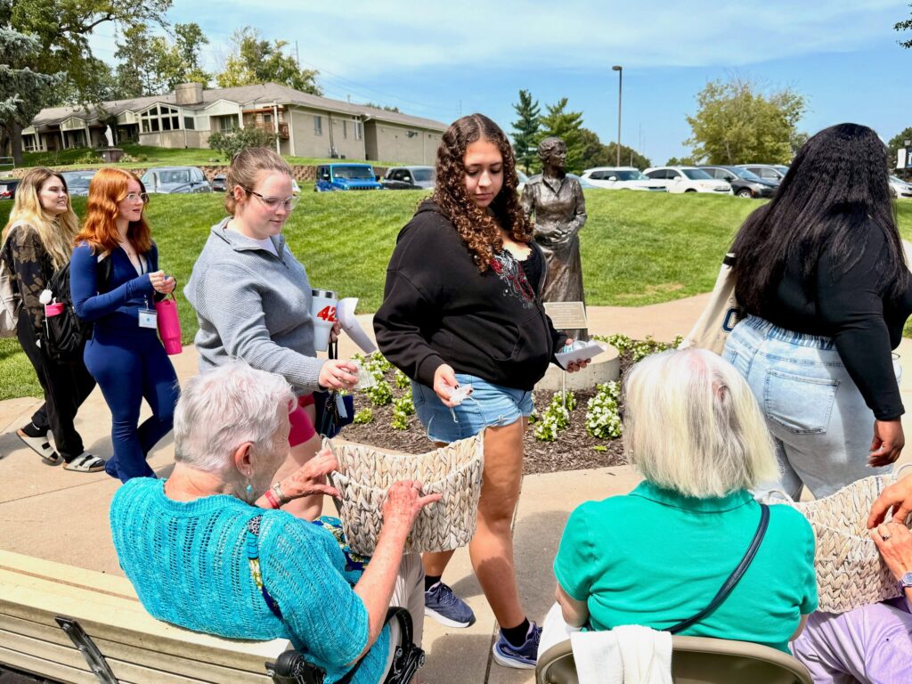 New students place daffodils in baskets held by Sisters of Mercy after Freshman Convocation.