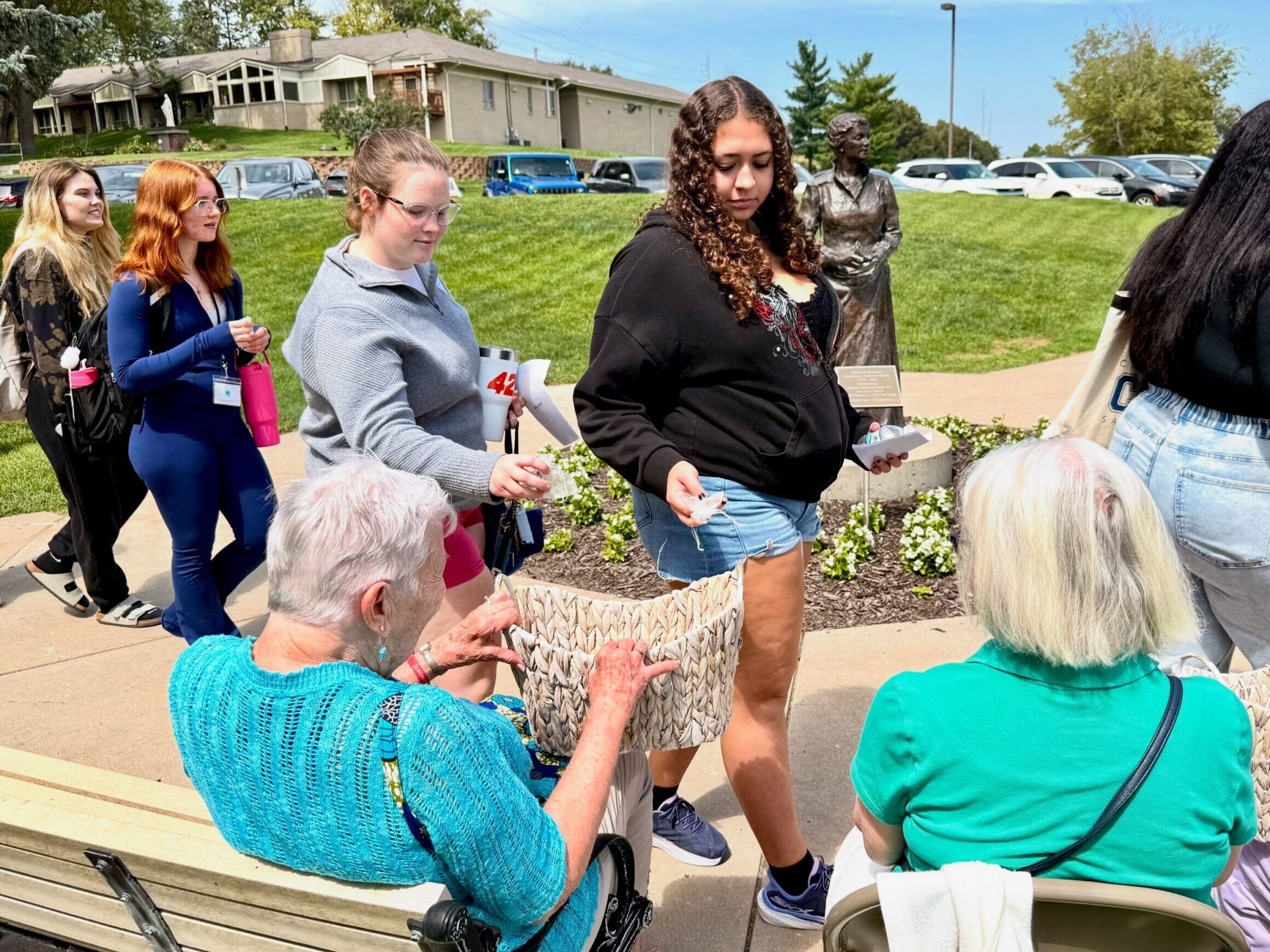 New students place daffodils in baskets held by Sisters of Mercy after Freshman Convocation.