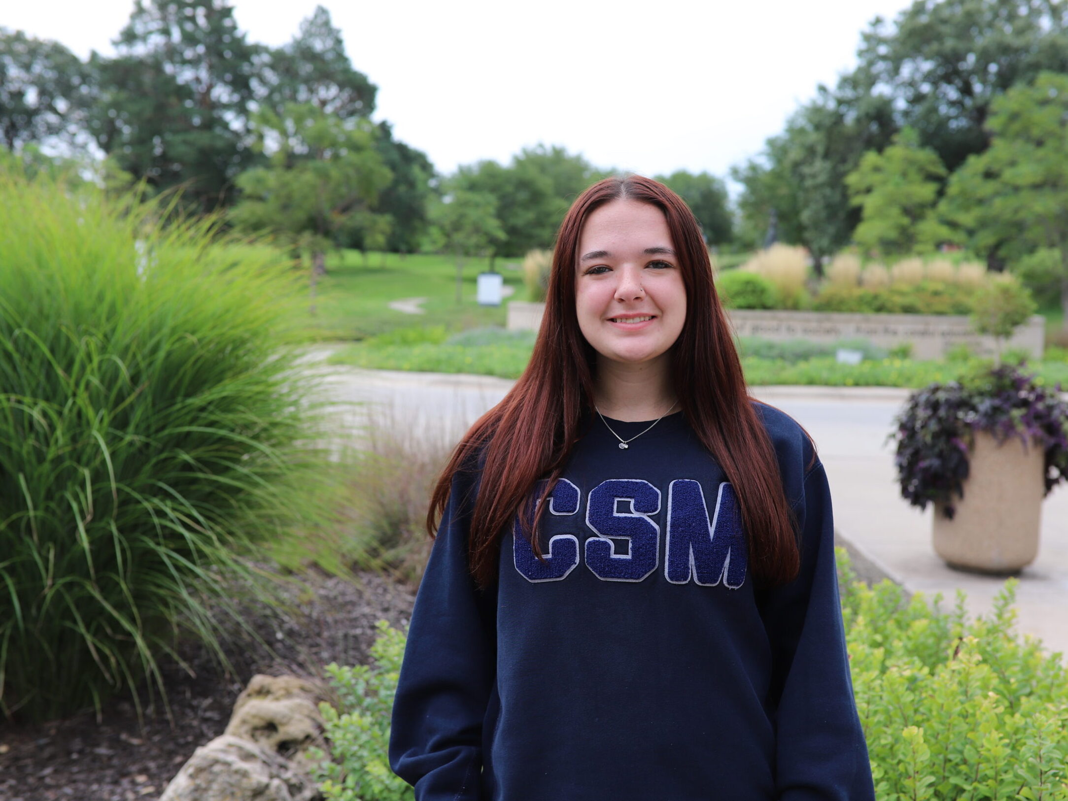 Marie Curie Scholar recipient Brigid Kelly stands in front of the Walking Woman statue on campus.